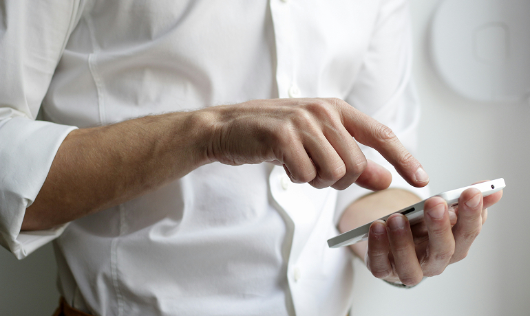 uomo che tiene in mano uno smartphone