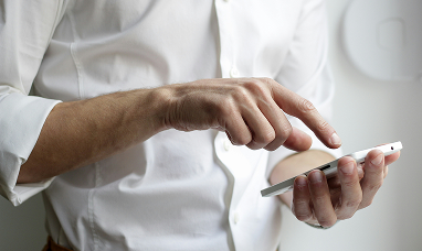 uomo che tiene in mano uno smartphone