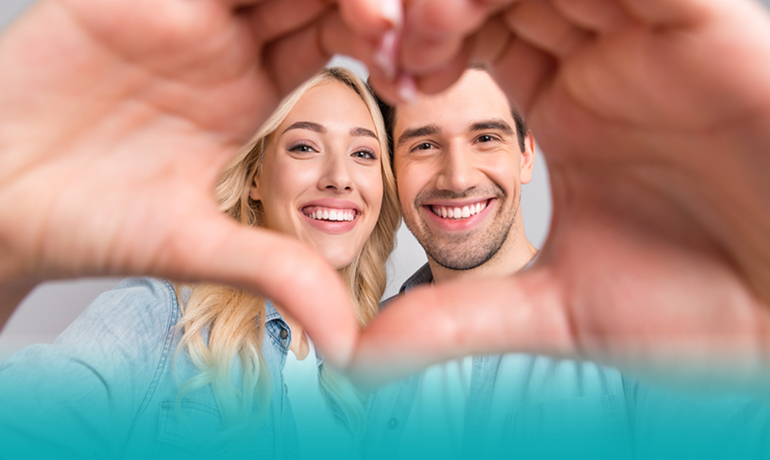Campagna Bonus Idrico Integrativo 2025, con un uomo e una donna che sorridono rivolti all'obiettivo e creano un cuore con le loro mani